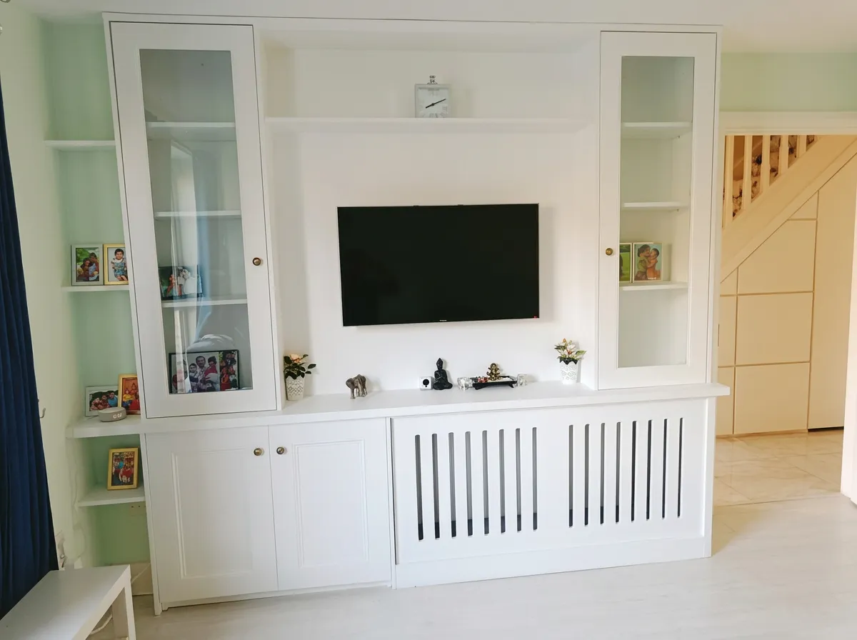 White media wall with glass-fronted cabinets, open shelving and an integrated slatted radiator cover